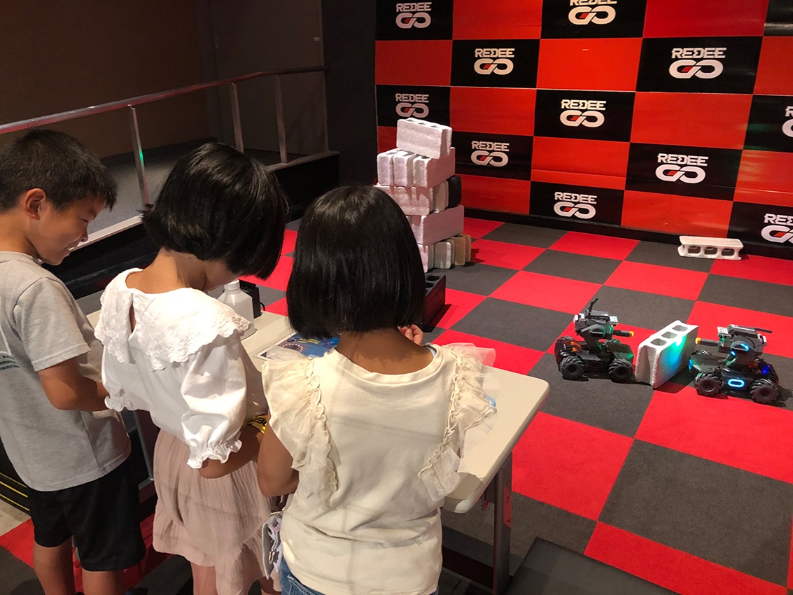 《陸上型ドローン体験》タブレットの操作で縦横無尽に移動できます。搭載したカメラで相手を認識し、対戦ゲームを楽しむこともできます。